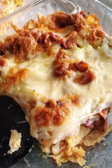 a cheesy croissant breakfast bake by Cleveland cooking served to guests. the bake includes bacon, egg, croissants, onion, and cheese.