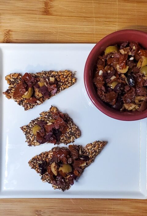 olive and sundried tomato tapenade on seed crackers.
