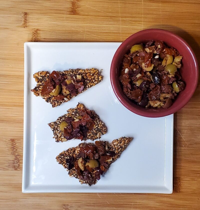 olive and sundried tomato tapenade on seed crackers.