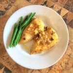 swiss cheese chicken bake with green beans. The chicken has swiss cheese and croutons baked on top. Recipe from cleveland cooking