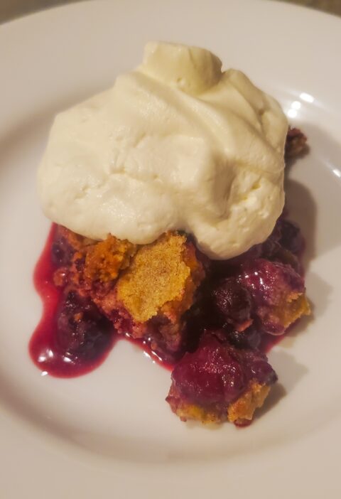 Mixed berry dessert with almond flour topping. A dollop of whipped cream on top. By cleveland cooking