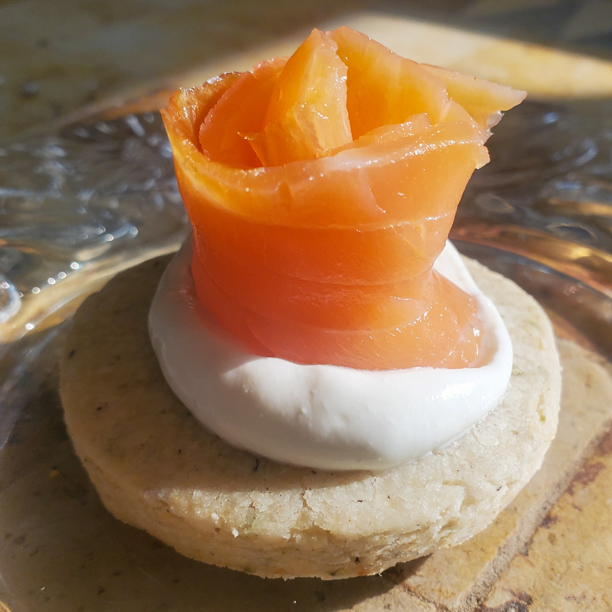 Smoked salmon with sour cream on a rosemary parmesan cracker from cleveland cooking.