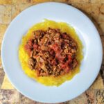 low carb Turkey chili with turkey, tomatoes, spices, and onions. The chili is on top of a bed of cooked spaghetti squash. recipe from cleveland cooking