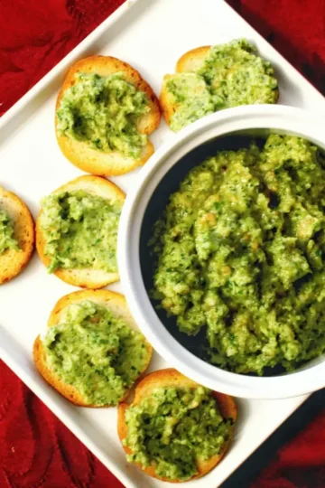 cheddar parsley pesto recipe made with cheddar cheese, olive oil, and garlic. The pesto is served on bagel rounds. Recipe from cleveland cooking