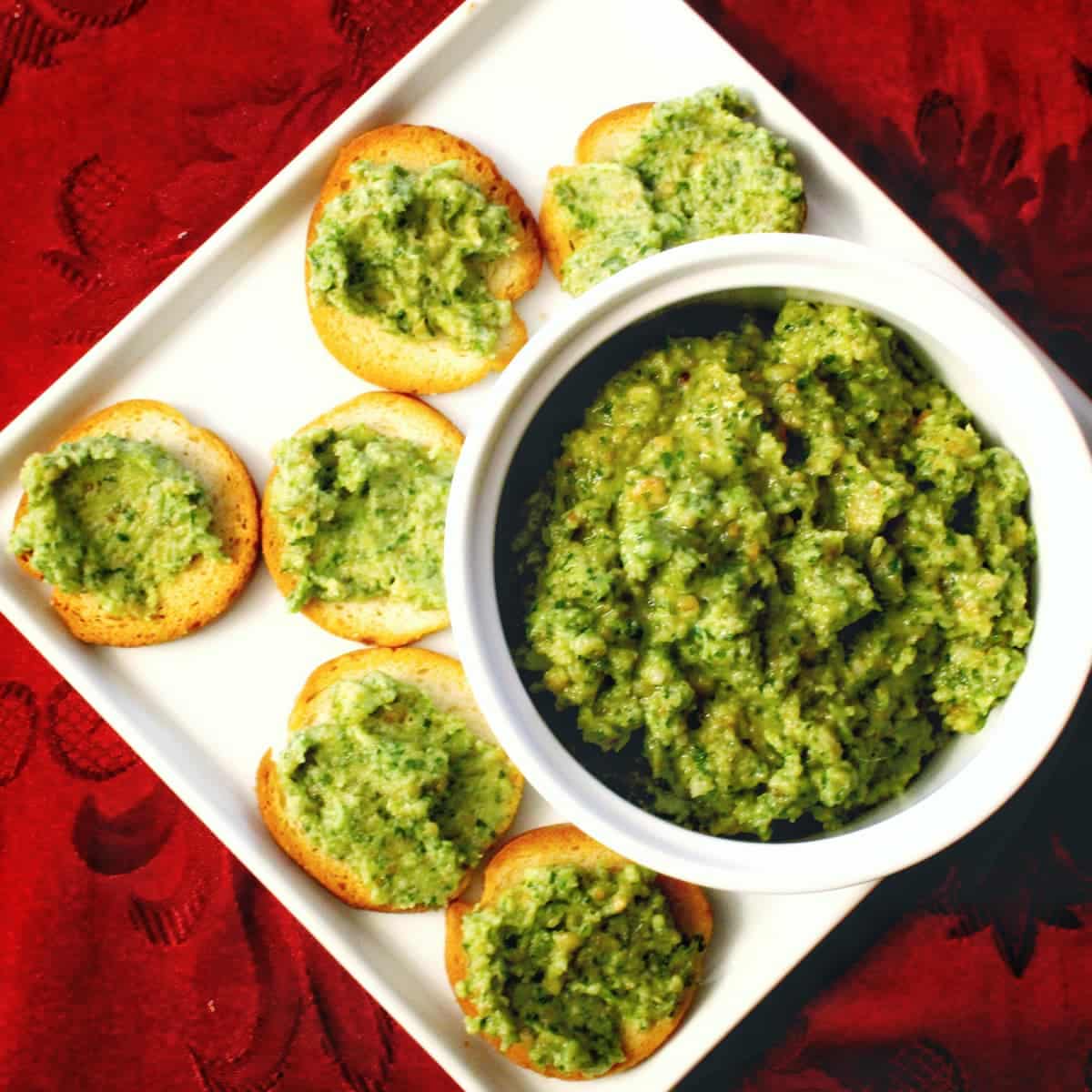 Walnut parsley pesto recipe made with cheddar cheese, olive oil, and garlic. The pesto is served on bagel rounds. Recipe from cleveland cooking