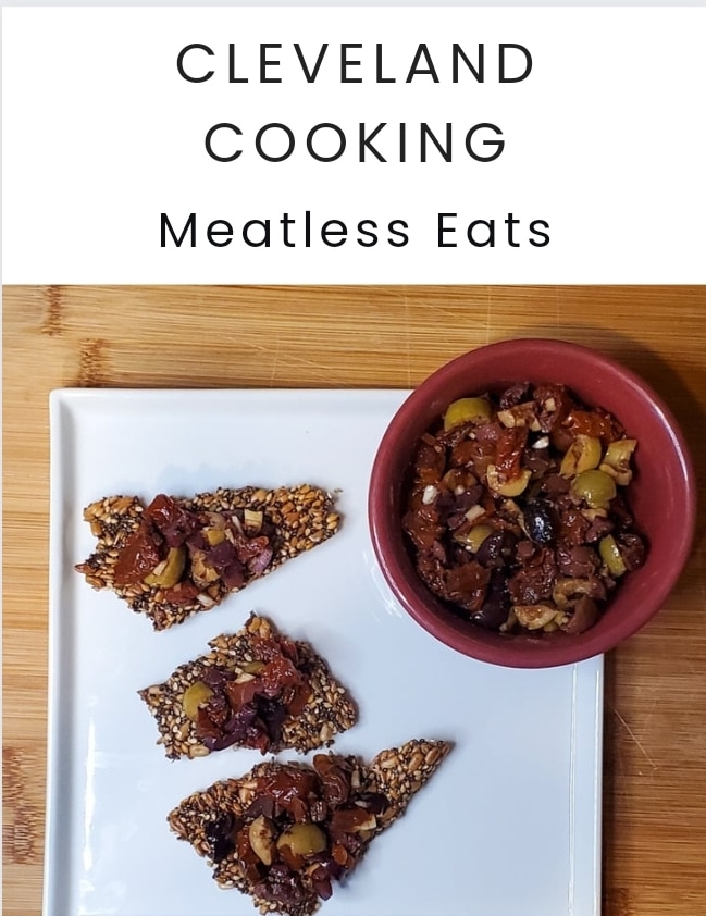 The cover of my meatless eats ebook. 6 recipes from cleveland cooking. on the cover is an olive tapenade recipe that is in the ebook. the tapenade is on seed crackers. click on the picture to download my ebook.