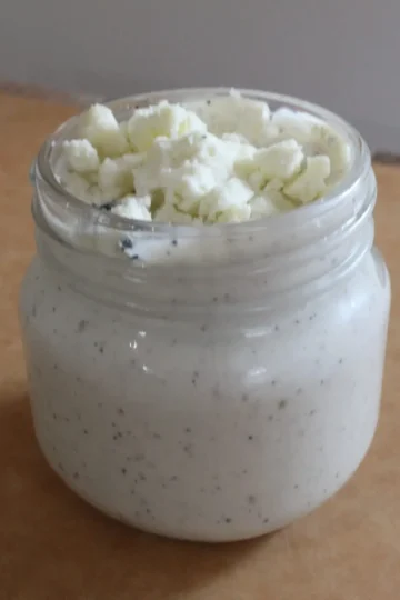 blue cheese dressing from Cleveland cooking. Blue cheese dressing in a jar with crumbled blue cheese on top.
