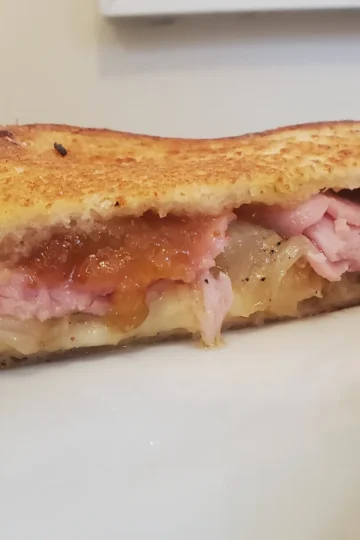 grilled cheese with fig jam from Cleveland cooking. The cheese, ham, grilled onions, and fig jam make a delicious upgrade for your grilled cheese.