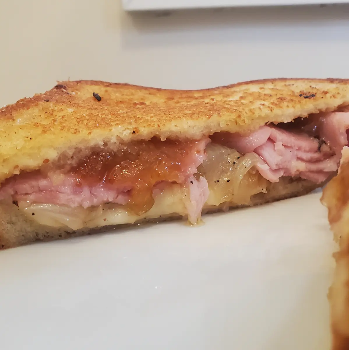 grilled cheese with fig jam from Cleveland cooking. The cheese, ham, grilled onions, and fig jam make a delicious upgrade for your grilled cheese.