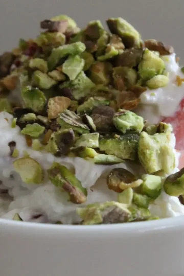 crumbled pistachios, whipped cream with cream cheese and sugar, and chopped strawberries make Strawberry Pistachio Fluff from Cleveland cooking.