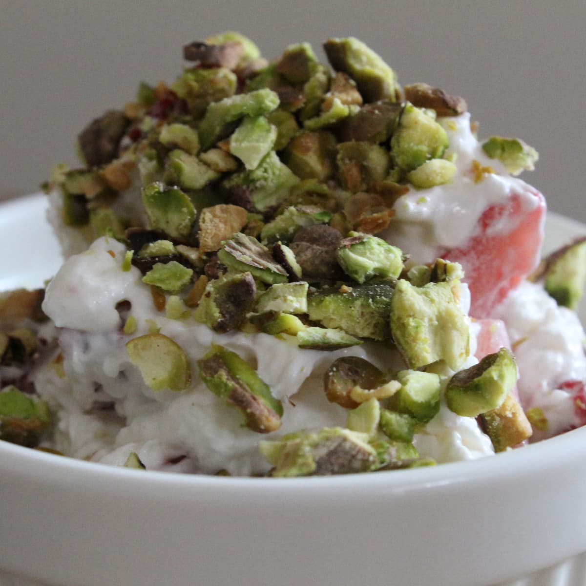 crumbles pistachios, whipped cream with cream cheese and sugar, and chopped strawberries make Strawberry Pistachio Fluff from Cleveland cooking.