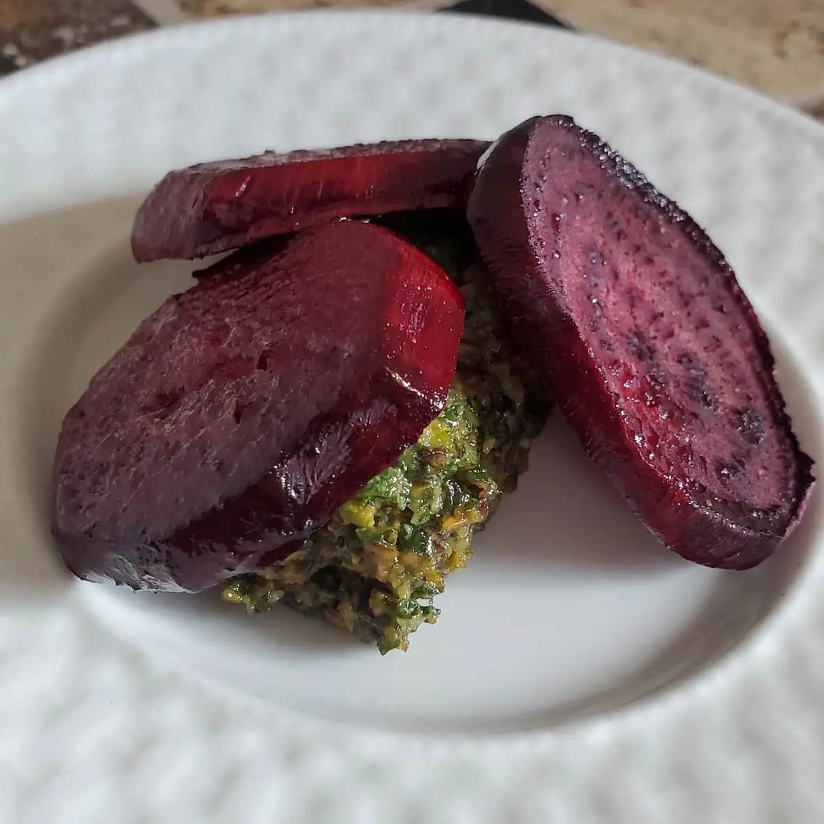 Roasted beets with beet greens pesto. The pesto is made from the greens of the beet stalks. it is made along with garlic and pistachios.