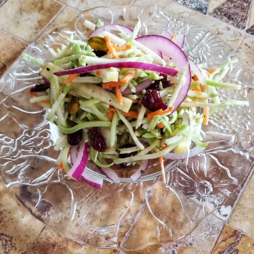 autumn broccoli slaw from Cleveland cooking. broccoli slaw, pecans, dried cranberries, and sliced apples.