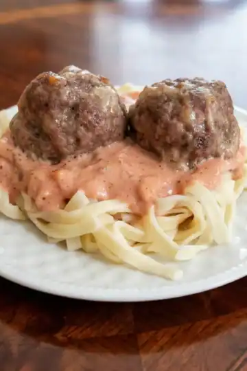 blush sauce recipe Cleveland cooking. 2 meatballs setting on top of a plate of homemade pasta with blush sauce.