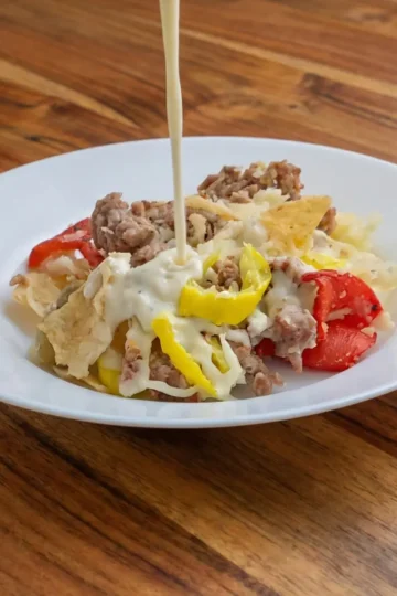 Asiago cheese sauce being poured over Italian nachos. Cleveland cooking.