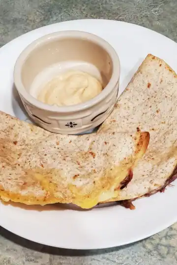 2 baked spiced quesadillas with pork, cheese and refried beans. the cup has a serving of everything sauce in it. that is used for the quesadillas. all the recipes are on clevelandcooking.com