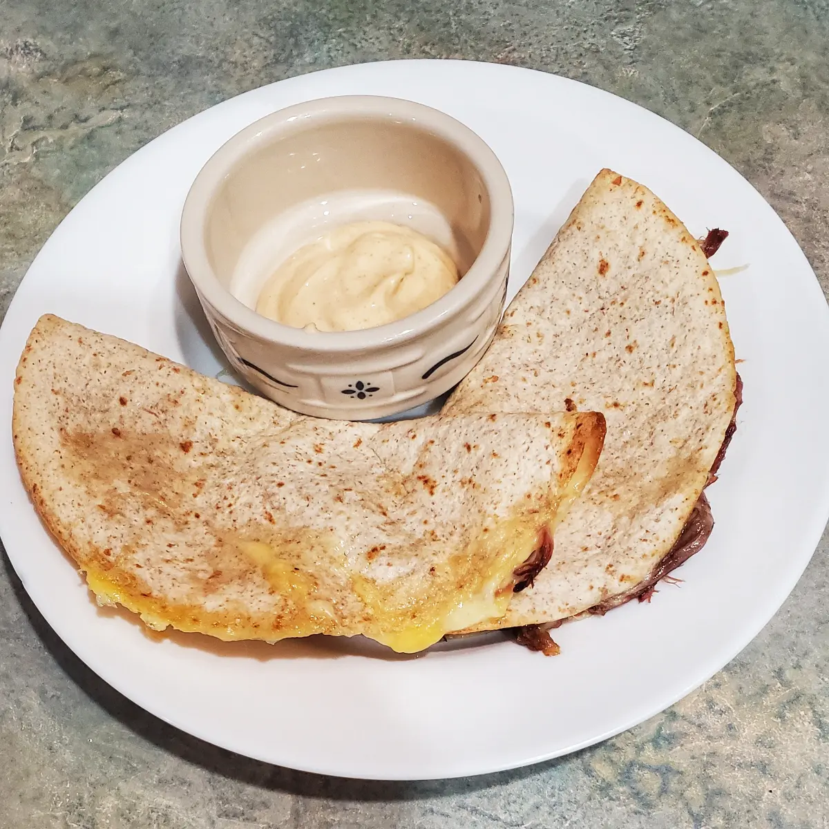 2 baked spiced quesadillas with pork, cheese and refried beans. the cup has a serving of everything sauce in it. that is used for the quesadillas. all the recipes are on clevelandcooking.com