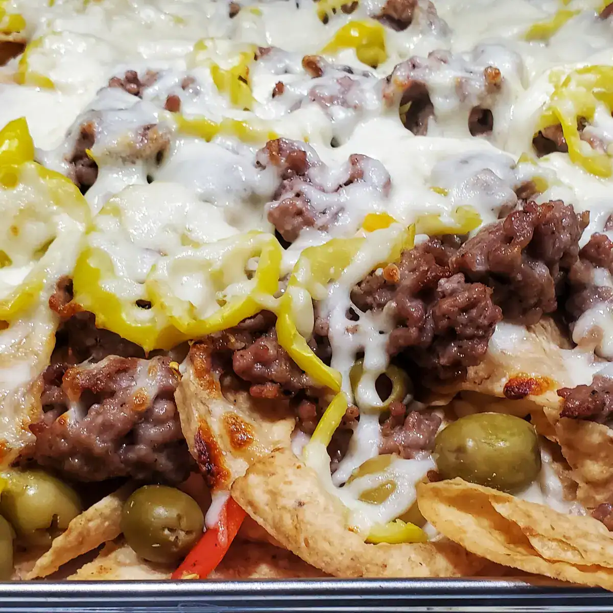 Italian nachos made of tortilla chips, Italian sausage, olives, and cheese fresh from the oven. Cleveland cooking