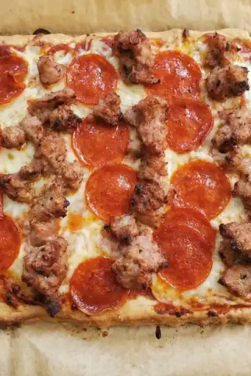 almond flour pizza crust. pizza with sausage and pepperoni toppings on a white plate. Cleveland cooking