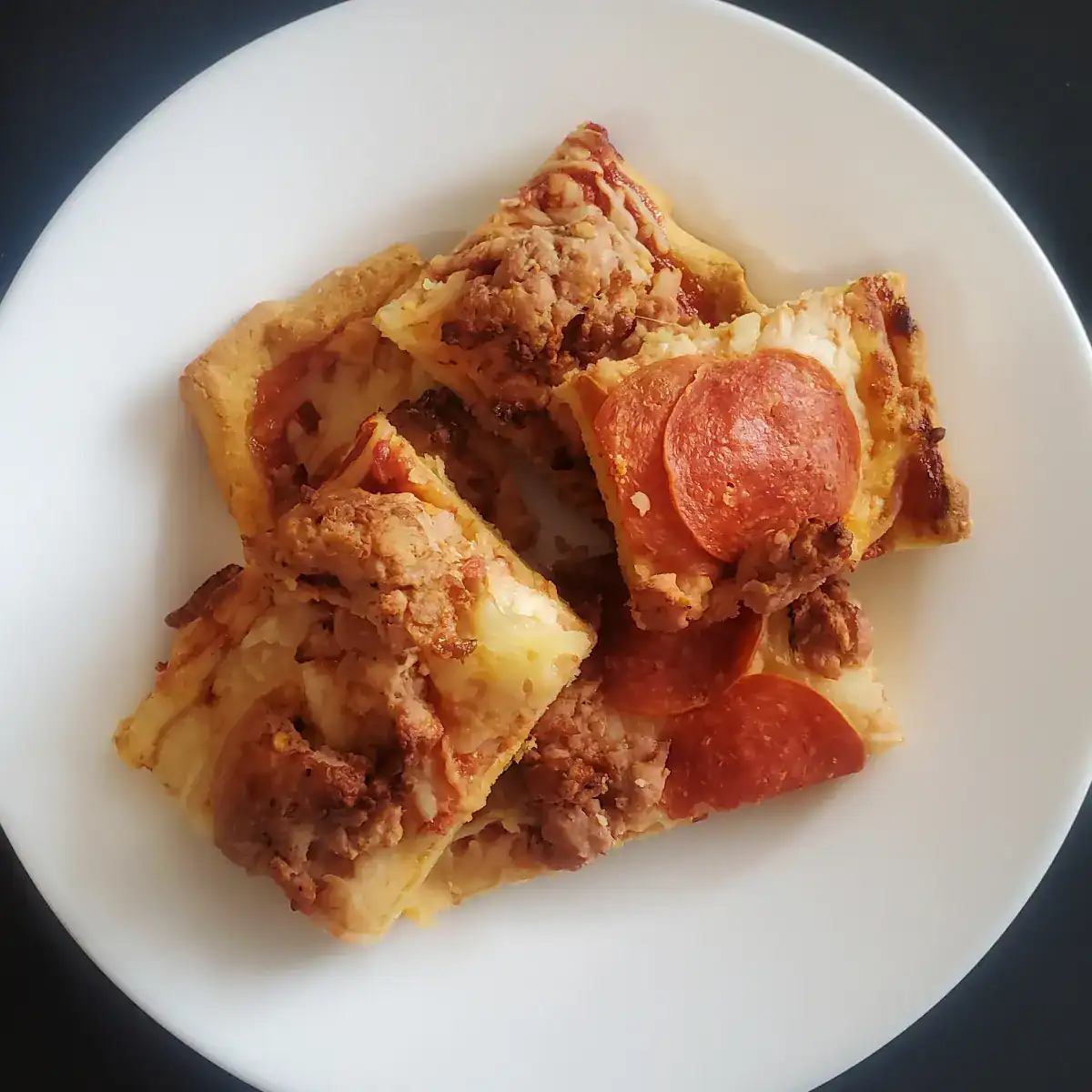 almond flour pizza crust. pizza with sausage and pepperoni toppings on a white plate. Cleveland cooking