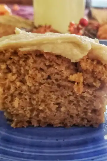 brown butter cream cheese frosting on top of a piece of pumpkin cake.