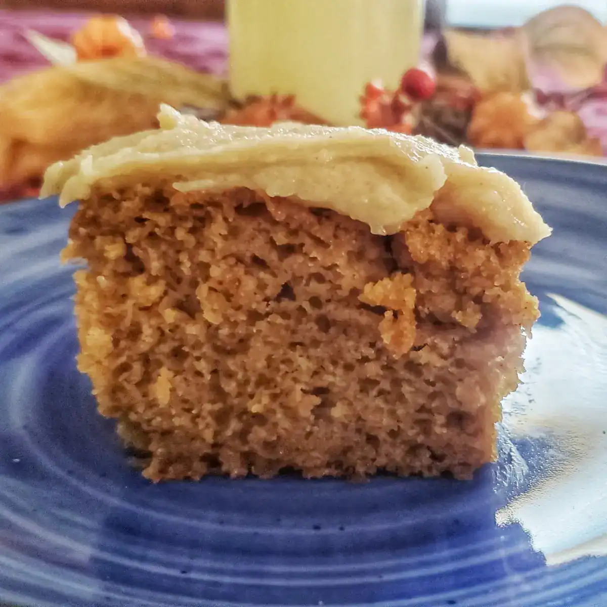 brown butter cream cheese frosting on top of a piece of pumpkin cake.