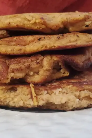 four pumpkin cottage cheese pancakes stacked on top of each other,